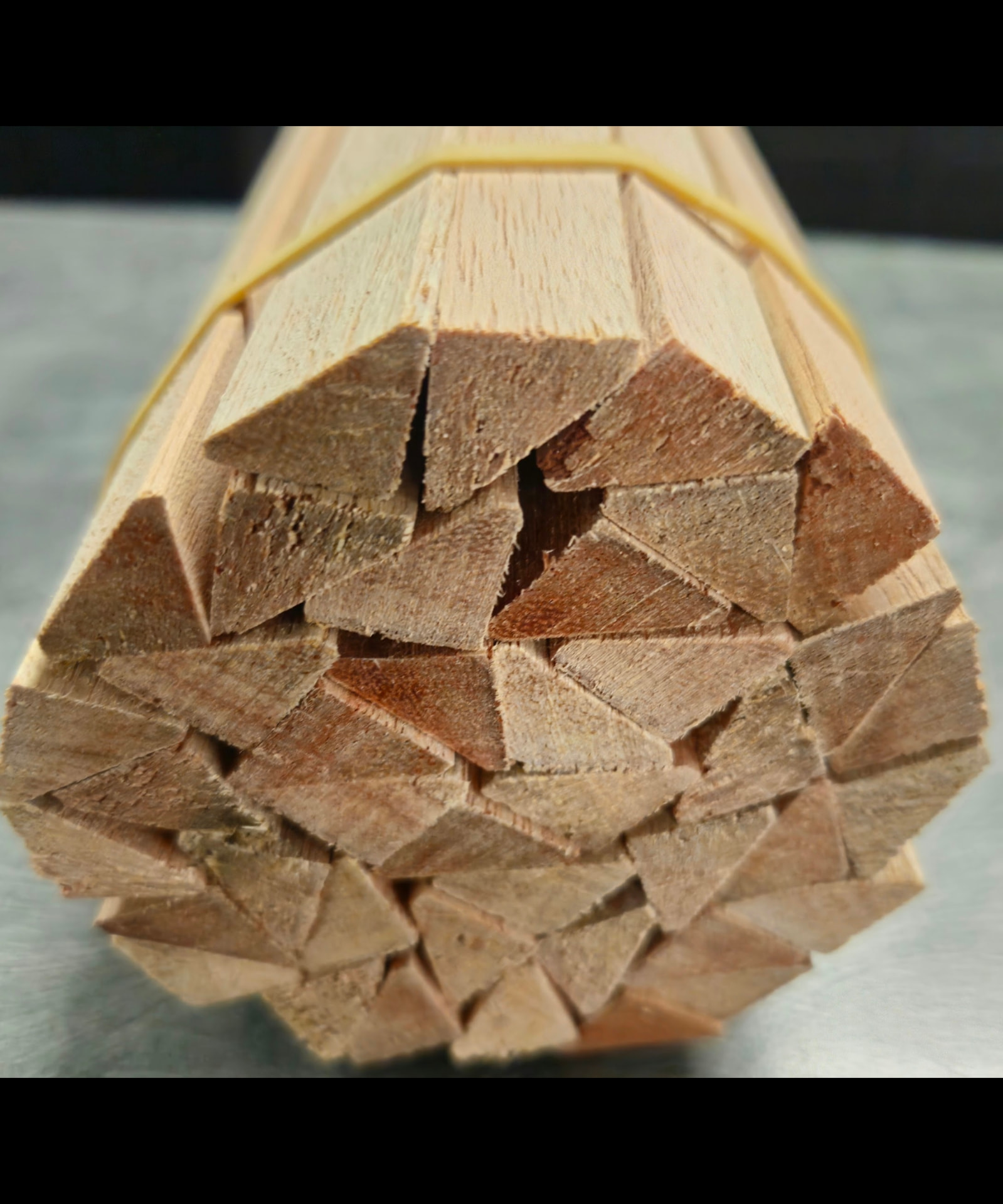 End view of a strapped bundle of triangular meranti beading